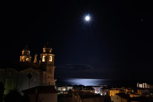a night view of a church with the moon in the sky at A Carubba du Bungiurnu in Borgio Verezzi