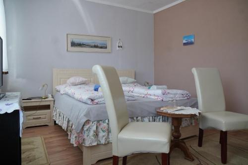 a bedroom with a bed and a table and chairs at Penzion Veronika in Štrba