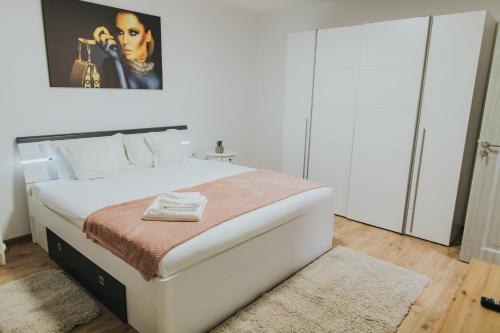 a bedroom with a large white bed in a room at Alessandra-Aparthotel in Piatra Neamţ