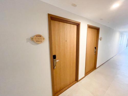 an empty hallway with two doors and a sign on the wall at The Title V Condos by Gregory in Rawai Beach