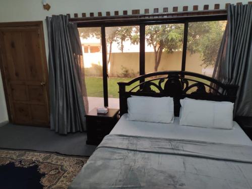 a bedroom with a bed and a large window at Askari Gold Crest in Peshawar