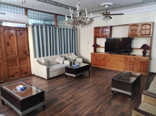 a living room with a couch and a tv at Askari Gold Crest in Peshawar