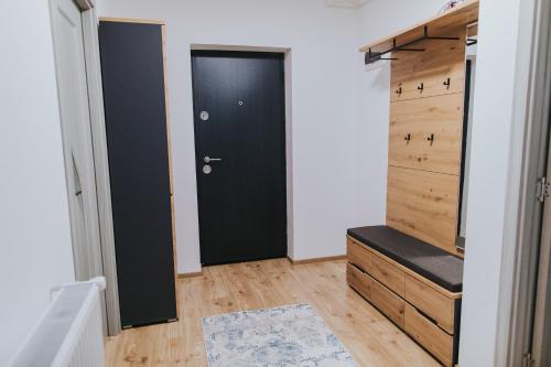a hallway with a black door and a closet at Alessandra-Aparthotel in Piatra Neamţ