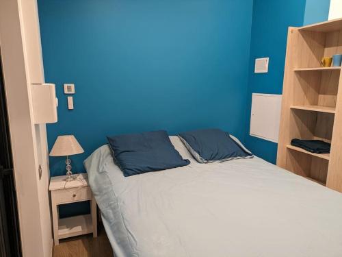 - une chambre bleue avec un lit et un mur bleu dans l'établissement Chambre indépendante à mougins, à Mougins