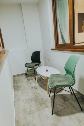 two chairs and a table in a room at Alessandra-Aparthotel in Piatra Neamţ