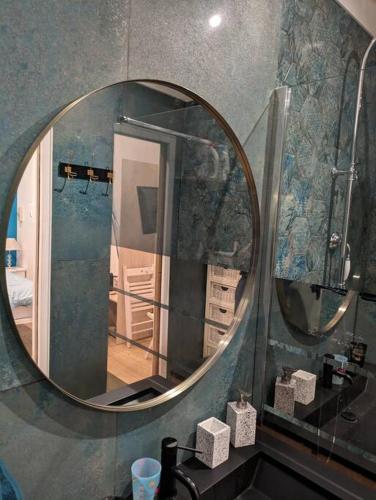 einem Spiegel im Bad mit Waschbecken und einem Zimmer in der Unterkunft Chambre indépendante à mougins in Mougins
