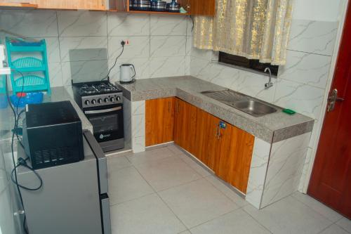 Il comprend une petite cuisine équipée d'un évier et d'une cuisinière. dans l'établissement Anne's comfy, à Mombasa