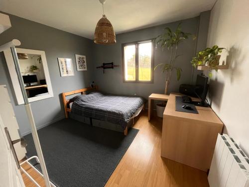 una camera con letto e scrivania con TV di Maison calme proche Paris et Disneyland a Précy-sur-Marne