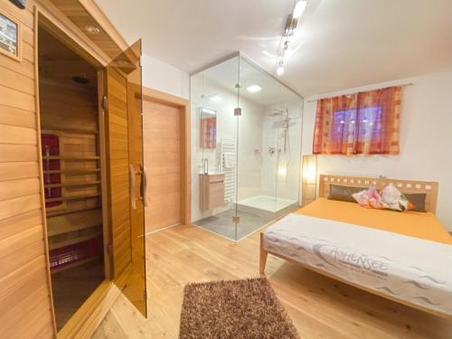a bedroom with a bed and a glass shower at Ferienhaus Alex in Wiesing
