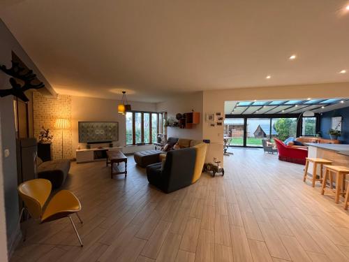 un grand salon avec un canapé et une télévision dans l'établissement Maison calme proche Paris et Disneyland, à Précy-sur-Marne