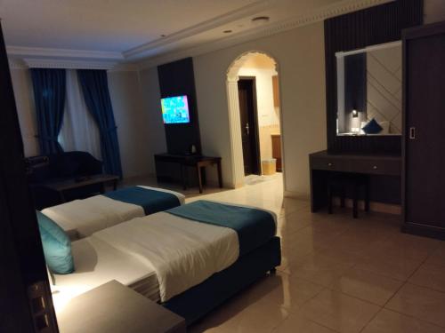 Habitación de hotel con 2 camas y TV de pantalla plana. en شقق اطلالة أبحر للشقق المخدومة en Yeda