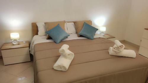 um quarto com uma cama grande e toalhas em Dimora Dante 310 em Bari