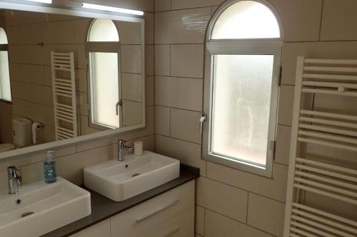 a bathroom with two sinks and two mirrors at Playa del Sol-Casa Playa in Denia