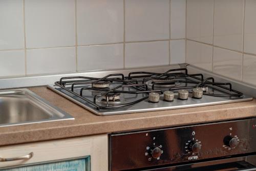 a stove top in a kitchen next to a sink at Sunset Home in Costa Paradiso