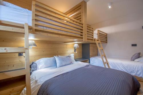 a bedroom with two bunk beds and a ladder at Chalet Caméline in Les Contamines-Montjoie