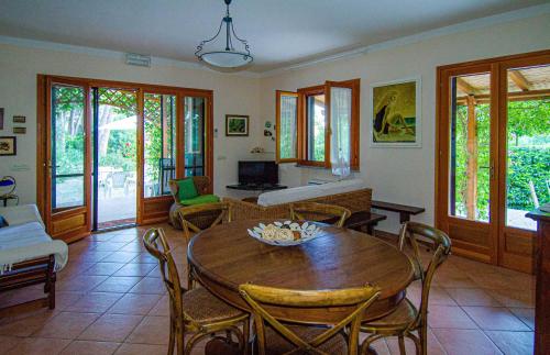 uma sala de estar com uma mesa de madeira e cadeiras em Lentisco terra e mare em Porto Azzurro