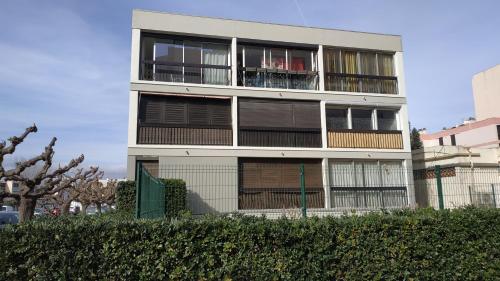 un bâtiment blanc avec des balcons sur le côté dans l'établissement Grand studio cabine à 100 m plage et commerces, à Saint Cyprien Plage