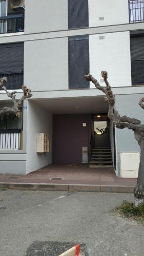 - un bâtiment avec une porte et des escaliers devant dans l'établissement Grand studio cabine à 100 m plage et commerces, à Saint Cyprien Plage