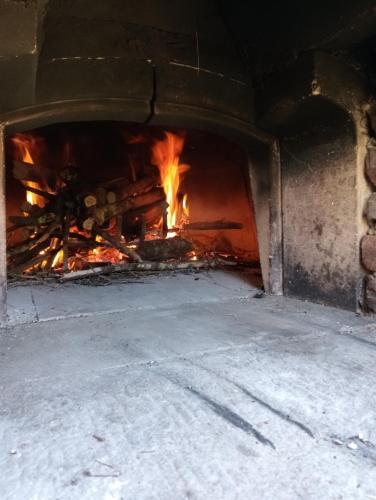 a large brick oven with fire in it at Le Macine in Magnano