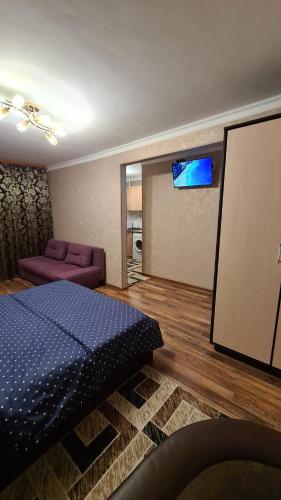 um quarto com uma cama e um sofá em Квартира посуточно в центре г.Петропавловска em Petropavl
