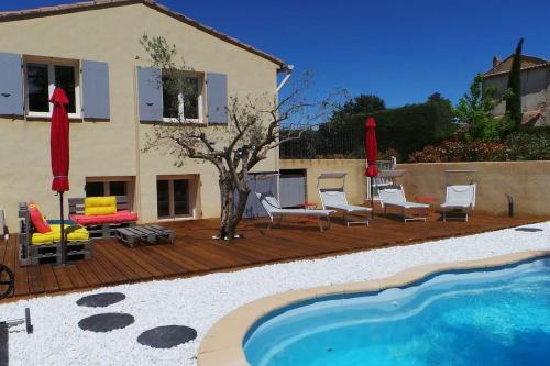 um deque de madeira com cadeiras e uma piscina em Jolie Maison avec jardin et piscine privée em Sablet