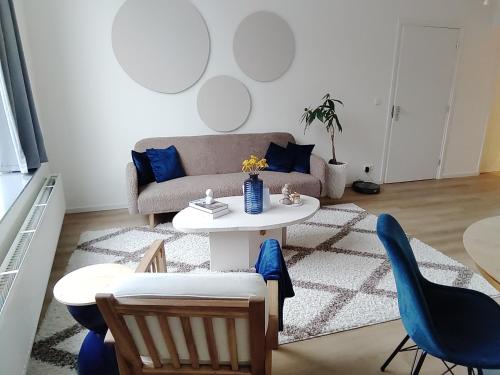sala de estar con sofá, mesa y sillas en Maya sweet rooms en Heerlen