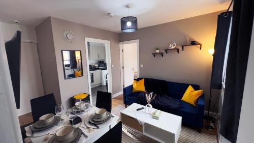a living room with a blue couch and a table at Stunning Cosy 2 Bedroom Flat with Parking, Central in Birmingham