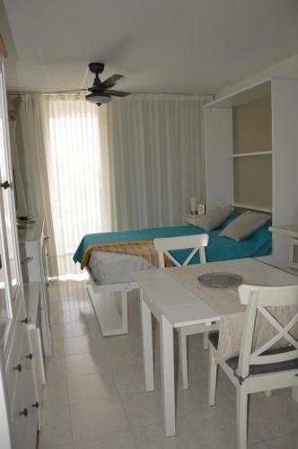 a bedroom with a bed and a table and a room at Studio Ponderosa in Playa de las Americas