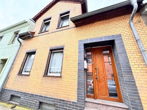 a brick building with a brown door and windows at Gästehaus EMELI in Lutherstadt Eisleben