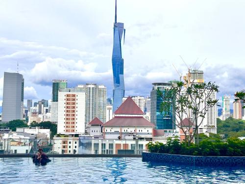 a man sitting in the water in front of a city at SS KL Sentral by NomadNest in Kuala Lumpur