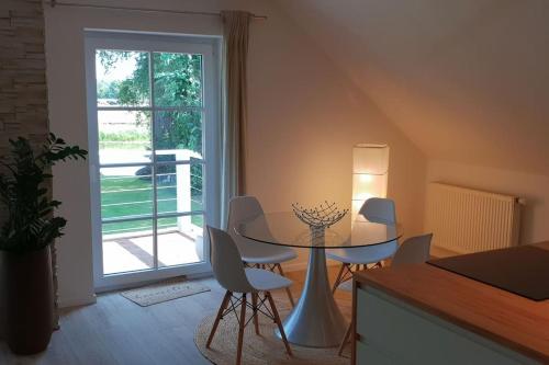 a dining room with a table and chairs and a window at FeWo-Heidekreis right along the old river Leine in Ahlden