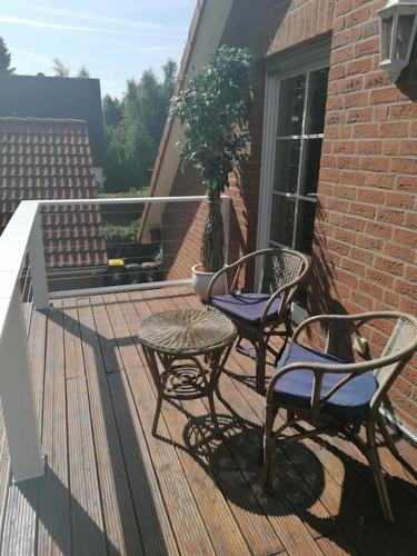 two chairs and a table on a wooden deck at FeWo-Heidekreis right along the old river Leine in Ahlden