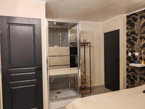 - une chambre avec une porte noire et un placard en verre dans l'établissement Hébergement proche aéroport de Nantes, à Saint-Aignan-Grand-Lieu