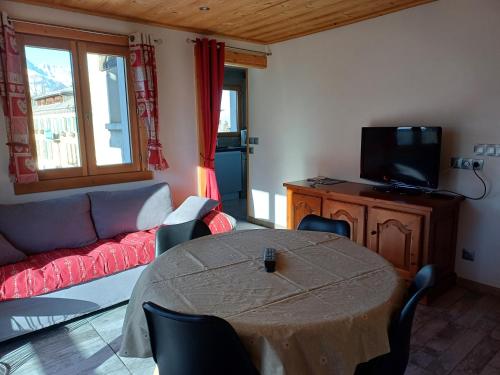 uma sala de estar com uma mesa e um sofá em chalet Mont-Blanc em Combloux