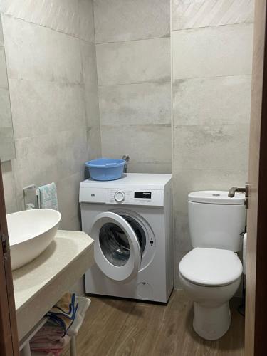 a bathroom with a toilet and a washing machine at Casa Capricho in Horcajo de las Torres