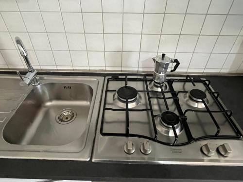 una cocina con fregadero, fogones y hervidor de agua. en Zambrone Beach Villas, en Zambrone
