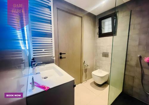a bathroom with a sink and a toilet at JourneyJoy I Luxury Apartment with Pool & Gym in Al Karm