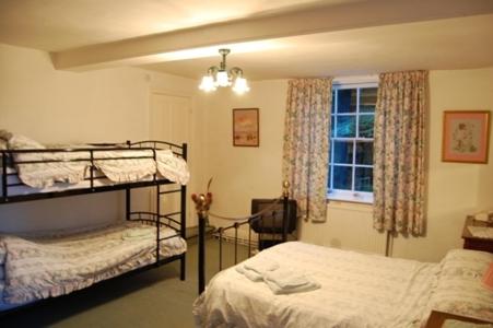 a bedroom with two bunk beds and a window at Abbot's Haye in Cheadle
