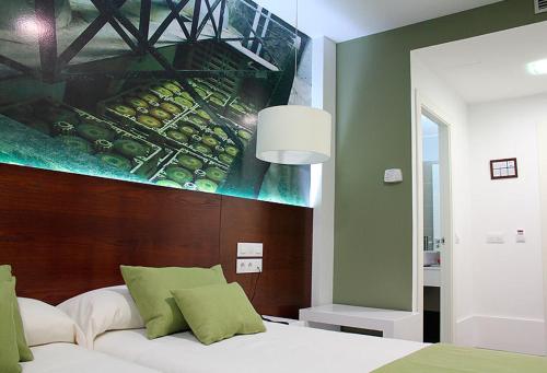 1 dormitorio con 1 cama con una pintura en la pared en Hotel La Casota, en La Solana