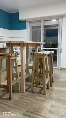 - une table en bois et des tabourets dans la cuisine dans l'établissement Casaquinta J&M, à Olavarría