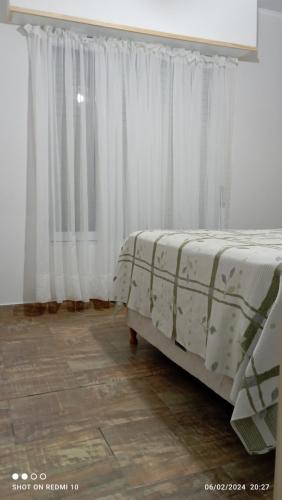 - une chambre avec 2 lits et une fenêtre avec des rideaux dans l'établissement Casaquinta J&M, à Olavarría