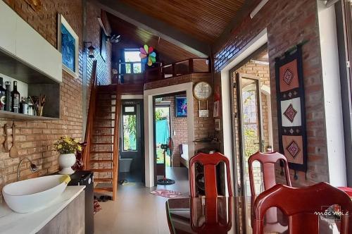 uma casa de banho com cadeiras vermelhas e uma parede de tijolos em Homestay Mộc Nhi em Hue