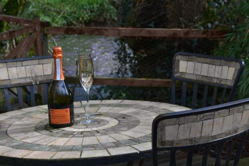 a bottle of wine sitting on a table with a glass at Colne Brook Barn in Alvington