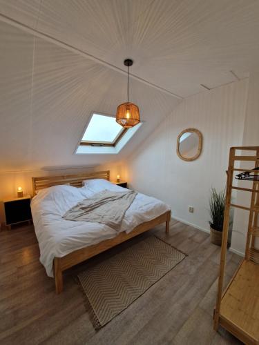 a bedroom with a large bed with a skylight at Appartement op topligging! in Cadzand