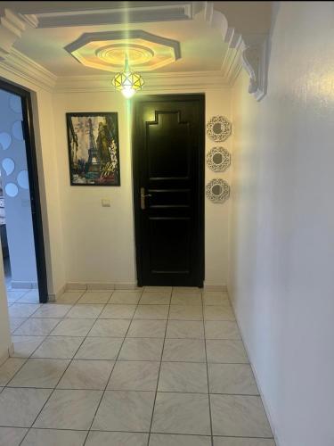 einen Flur mit einer schwarzen Tür und einer Decke in der Unterkunft Appartement centre Agadir in Agadir