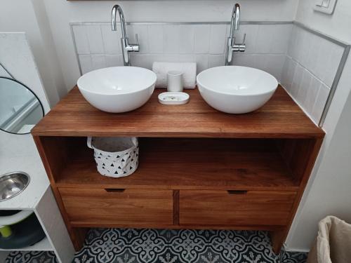 twee wastafels op een houten aanrecht in een badkamer bij Cocon familial proche de Paris in Issy-les-Moulineaux