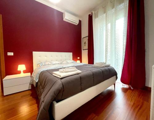 a bedroom with a large bed with red walls at Lucens Domus Appartamento Roma quartiere Trieste - vicino Metro b1 - in Rome