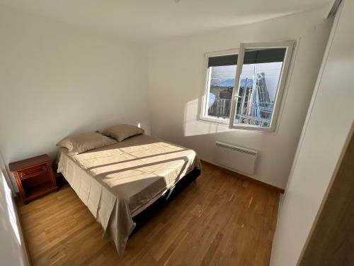 Habitación pequeña con cama y ventana en Maison cosy avec jardin calme, en Savigny-sur-Orge