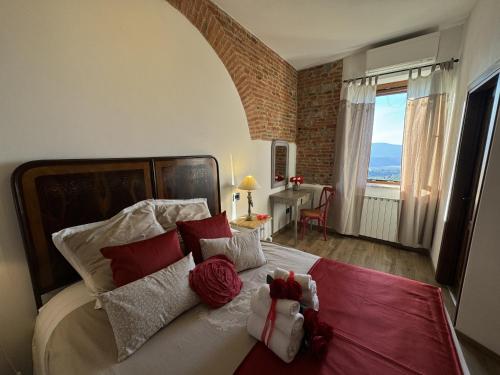 a bedroom with a large bed with red and white pillows at B&B La Casa del Sarto in Città della Pieve