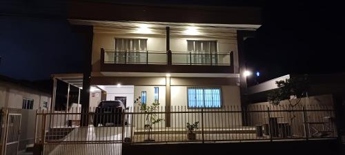 una casa por la noche con balcón en 1- Casa em Itapema com 3 quartos e 2 andares en Itapema